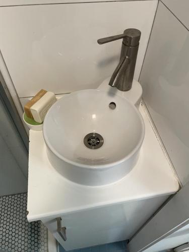 a white sink in a bathroom with a fosset at California guest house in Greenwich