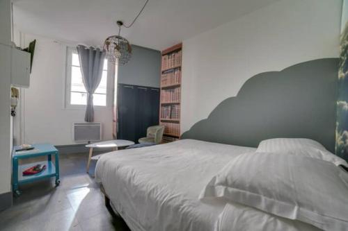 une chambre avec un lit, un bureau et une fenêtre dans l'établissement La tête dans les nuages, à Rouen