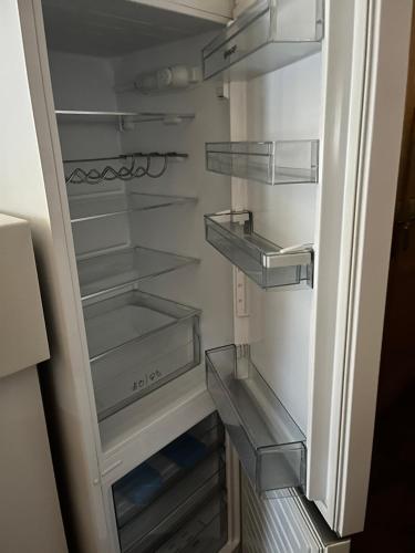a refrigerator with its door open with its empty shelves at Villa Maxime in Porto-Vecchio