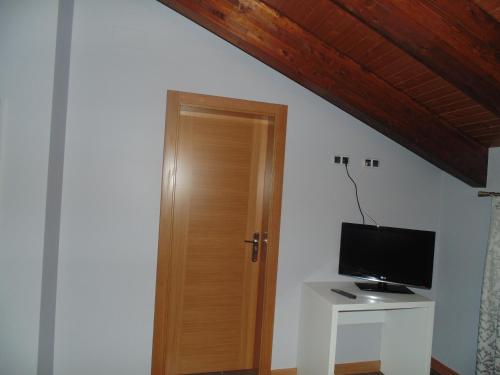 a room with a wooden door and a television at Hotel Ribera de Langa in Langa de Duero