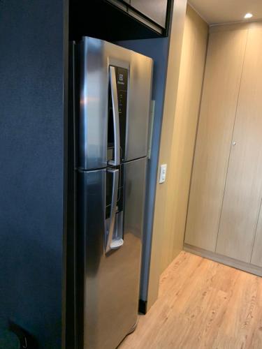 a stainless steel refrigerator in the corner of a kitchen at Modernidade e conforto para sua hospedagem !!! in Sao Paulo