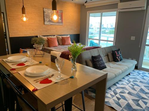 a living room with a table and a couch at Modernidade e conforto para sua hospedagem !!! in Sao Paulo
