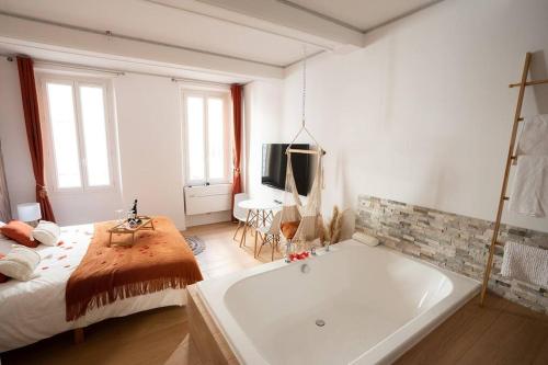 a bathroom with a large tub in a bedroom at Ode à l'amour : studio intimiste in Toulon