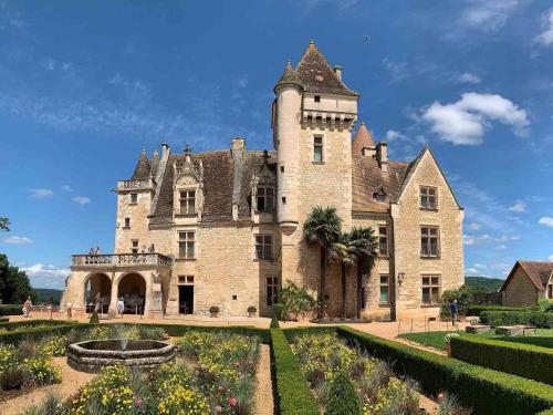 um velho castelo com um jardim em frente em Brasseurs Du Pont - Microbrasserie avec chambres em Siorac-en-Périgord