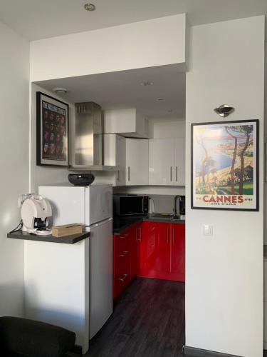 une cuisine avec des armoires rouges et un réfrigérateur blanc dans l'établissement Appartement 2 pièces centre ville Cannes, à Cannes