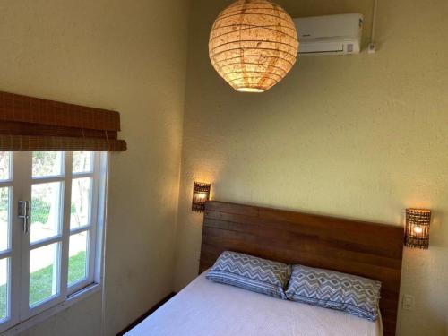 a bedroom with a bed and a large window at Morada dos Coqueiros in Garopaba