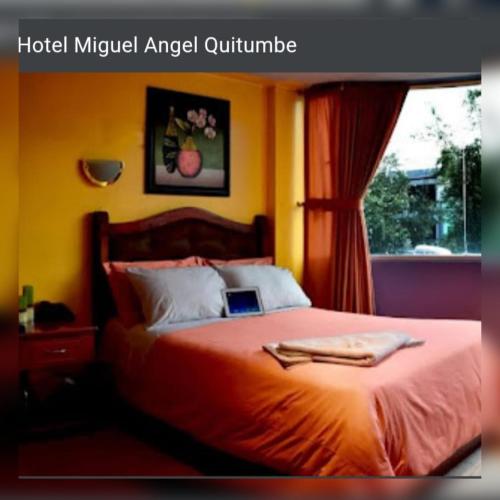 a bedroom with a bed with a laptop on it at Hostal Miguel Ángel in Quito