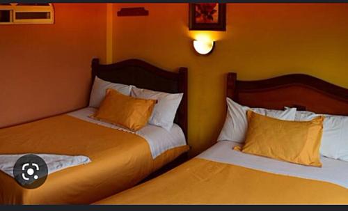two beds sitting next to each other in a room at Hostal Miguel Ángel in Quito