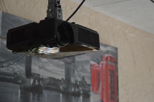 a tv hanging from the ceiling in a room at Logis Hôtel & Restaurant Le Fleurance in Fleurance