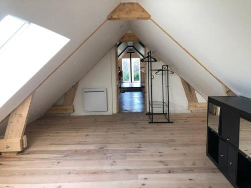 Cette chambre dispose d'un toit avec du parquet. dans l'établissement Steen Home : Petite longère de charme, à Boeschèpe