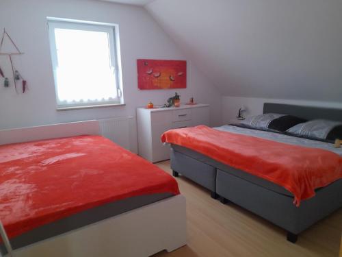 a bedroom with two beds and a window at Ferienwohnung Ina in Michelau