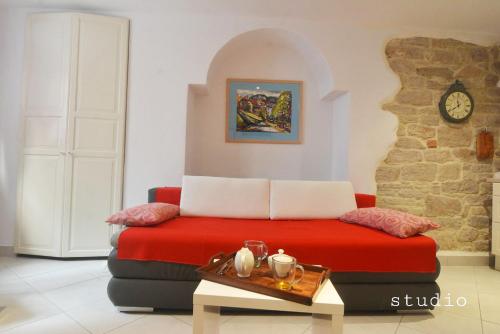 a living room with a red couch and a table at All My Loving in Rovinj