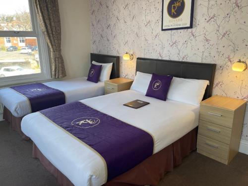 a hotel room with two beds and a window at Revado Hotel in Norwich