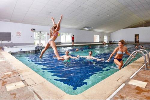 a group of people in a swimming pool at Recently refurbished 3 bed Villa & superfast wifi in Michaelstow
