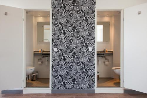 a bathroom with a black and white shower curtain at St Christopher's Inn Paris - Gare du Nord in Paris