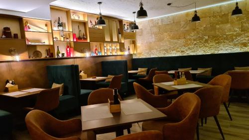 a restaurant with tables and chairs and a bar at B&B Plitvice Holiday Lodge in Plitvička Jezera