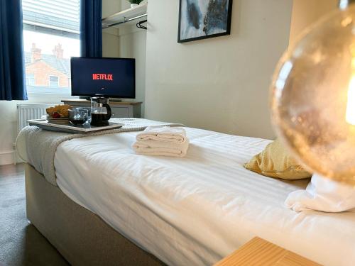 een slaapkamer met een bed en een televisie. bij Whitworth House, Sleeps 6 TVs in all bedrooms, WIFI - 3 bedroom in Northampton