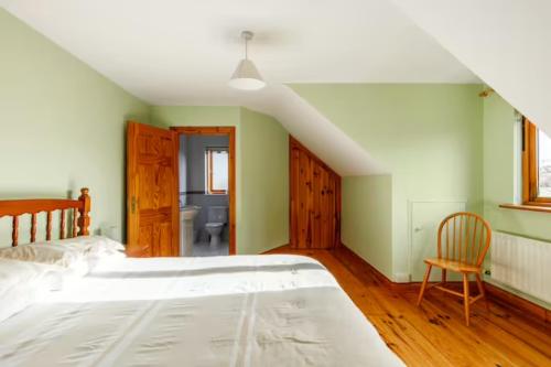 1 dormitorio con 1 cama blanca grande y 1 silla en Yellow House, en Westport