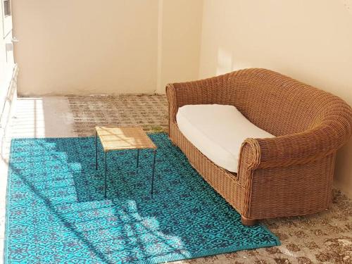 a wicker chair and a table on a rug at [PIAZZA GARIBALDI] ELEGANTI SUITE CON SAUNA in Udine