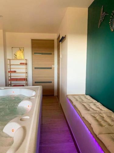 a bathroom with a bath tub with a bed in it at L'ÉCHAPPÉE BRETONNE in Plouider
