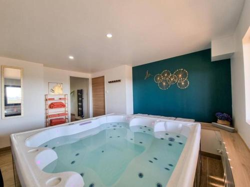 a hot tub in a room with a green wall at L'ÉCHAPPÉE BRETONNE in Plouider