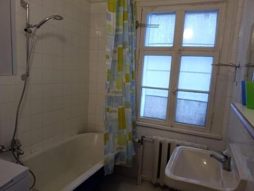 baño con bañera, lavabo y ventana en Kodu majutus, en Tallin