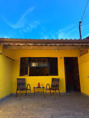 two chairs and a table in front of a yellow house at Casa Amarela in Paraty