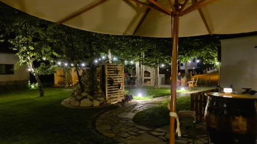 an umbrella in a garden at night with lights at B&B Plitvice Holiday Lodge in Plitvička Jezera