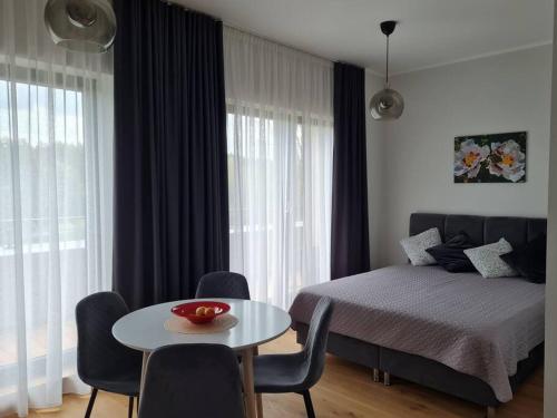een slaapkamer met een bed en een tafel en stoelen bij Seaside Apartment "Sunrise" with terrace in Ķesterciems, Albatross in Ķesterciems