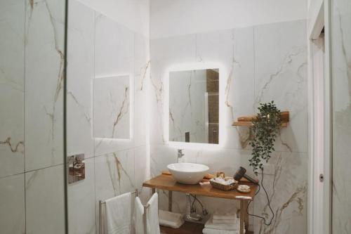 La salle de bains est pourvue d'un lavabo et d'un miroir. dans l'établissement Sisina Luxury Room Jacuzzi & Piscina, à Portici