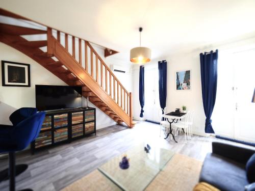 salon ze schodami i kanapą w obiekcie LE PLAISANCE - Face au Parc - Duplex - Balcon w mieście Vichy