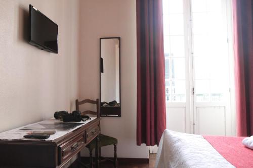 um quarto com uma cómoda com um espelho e uma cama em Hotel GORDON em Funchal