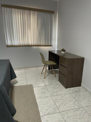 a bedroom with a desk and a chair and a table at Apartamento amplo, confortável e equipado - Apt 101 in Anápolis