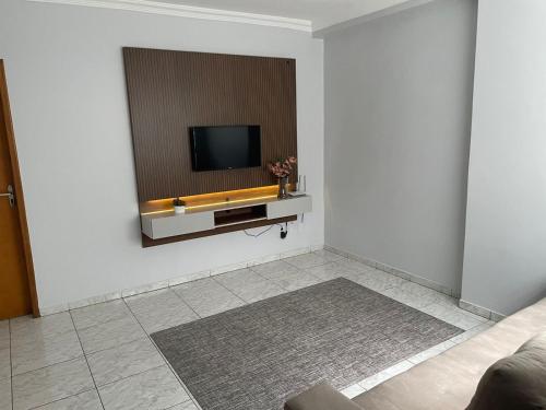 a living room with a television on a wall at Apartamento amplo, confortável e equipado - Apt 101 in Anápolis