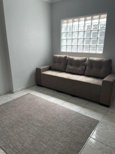 a couch in a living room with a window at Apartamento amplo, confortável e equipado - Apt 101 in Anápolis