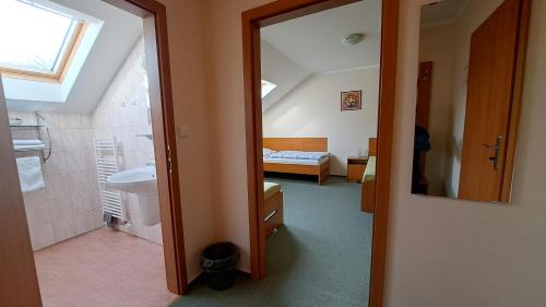 ein Bad mit einer Dusche und ein Schlafzimmer mit einem Bett in der Unterkunft Penzion Aida Ostrava in Ostrava