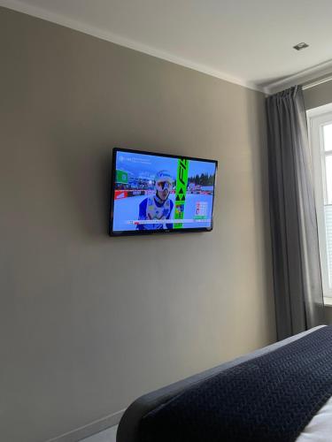 TV de pantalla plana en la pared de un dormitorio en Privatzimmer Steinmetz in Reken, en Reken