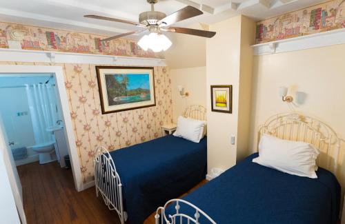 um quarto com 2 camas e uma ventoinha de tecto em The Heirloom Inn em Mount Dora