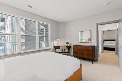 a bedroom with a bed and a desk and windows at WhyHotel by Placemakr, Columbia in Columbia