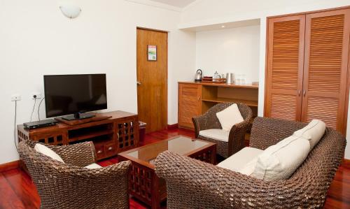 a living room with chairs and a flat screen tv at The Naviti Resort in Korolevu