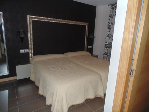 a bedroom with a bed with a large headboard at Hotel Ribera de Langa in Langa de Duero