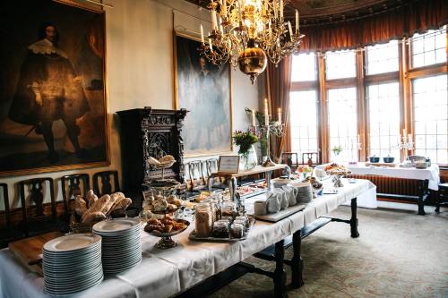 una sala da pranzo con un lungo tavolo con piatti e cibo di Teleborgs Slott a Växjö