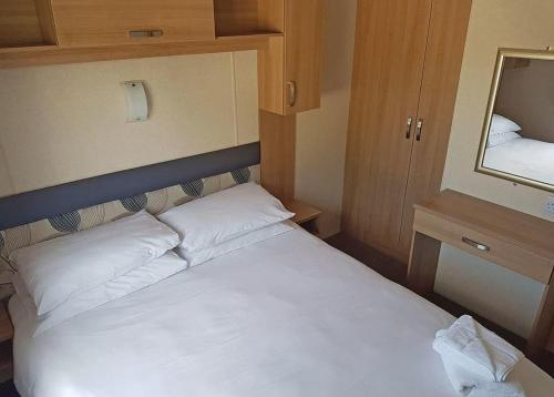 um quarto com uma cama branca e um espelho em Rosneath Castle Park em Rhu