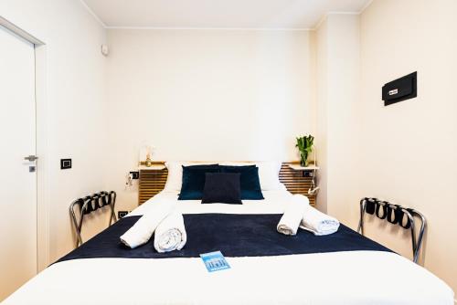 a bedroom with a large white bed with blue sheets at Gegix's Rooms Milano in Milan