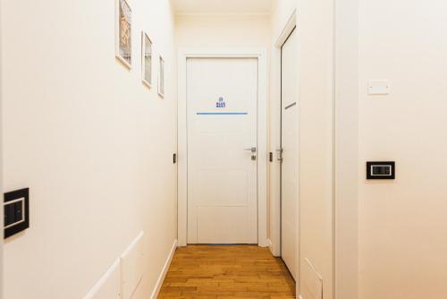 a hallway with a white door and a wooden floor at Gegix's Rooms Milano in Milan