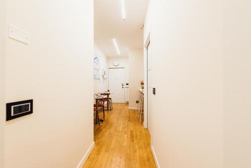 a hallway with white walls and a wooden floor at Gegix's Rooms Milano in Milan