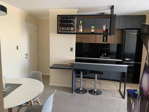 cocina con encimera y mesa con sillas en Departamento Full Amoblado en Talca en Talca