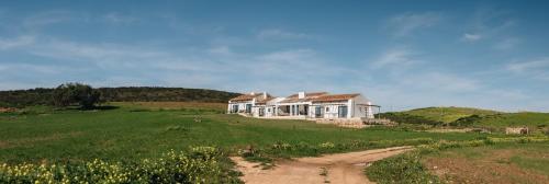 a house on a hill with a dirt road in front at Casa Nook Sagres in Vila do Bispo