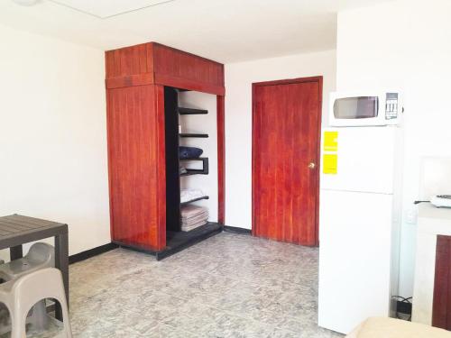 a kitchen with a cupboard and a refrigerator at Hospedaje Via 7 in Guatemala