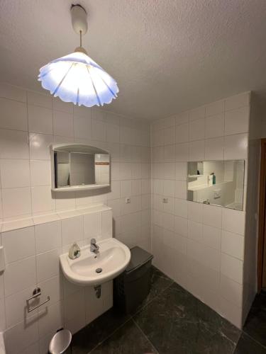a bathroom with a sink and a toilet and a light at Gashthaus zur Arche in Riegel